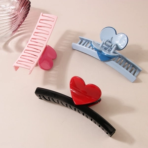 Lot de trois grandes pinces à cheveux colorées avec des motifs de cœur en rose, bleu et noir