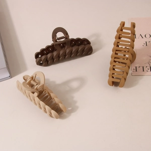 Three large matte claw clips with chain design in earthy tones for hair styling
