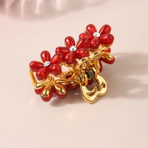 Pinza per capelli dorata con fiori in resina rossa e cristalli brillanti vista a 45 gradi
