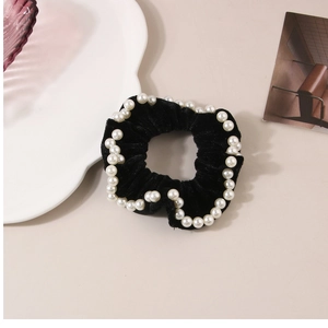 Dettaglio di elastico in velluto nero con eleganti perle finte bianche lungo il bordo