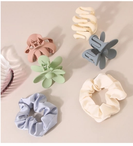 Close-up of minimalist hair claw clips and satin scrunchies in soft morandi colors