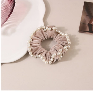 Dettaglio dell'elastico in velluto rosa con bordo di perle e texture morbida