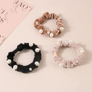 Three velvet hair scrunchies with white pearls in black, brown, and beige colors