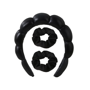 Dettaglio di un cerchietto a nuvola nero con due elastici per capelli in tessuto coordinati