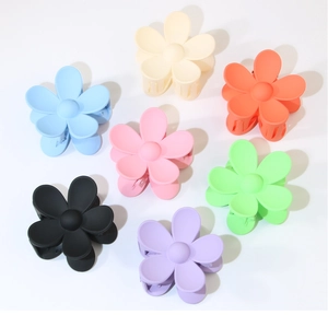 Detailed view of matte flower hair claws in seven assorted pastel and neutral colors