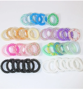 Flat lay view of a colorful set of elastic spiral hair ties in various vibrant colors