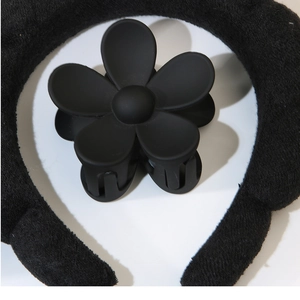 Close-up of matte black flower hair claw clip and plush headband minimalist hair set