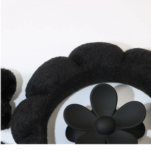 Detailed close-up of a black fuzzy headband and matte floral hair claw clip accessory set