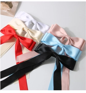 Détail macro de nœuds de cheveux en satin multicolores avec de longs rubans soyeux
