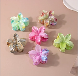 Détail d'un lot de 6 pinces à cheveux en forme de fleur avec texture marbrée en acétate
