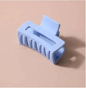 Detailed view of rectangular matte blue hair claw clip with frosted texture finish