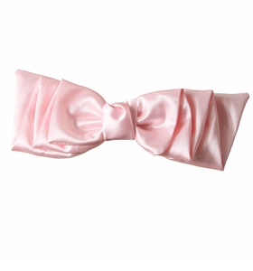 Dettaglio fermaglio per capelli con fiocco in raso rosa e design a strati setosi