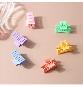 Detailed view of six candy-colored matte rectangular hair claw clips arranged in a circle