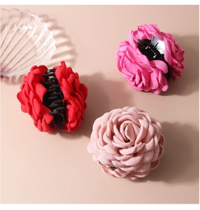 Detailed close-up of textile rose hair claws in red, magenta and pink colors