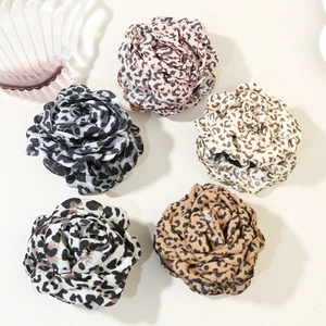 Five leopard print fabric rose flower hair claws displayed in diverse color variations