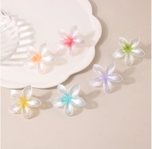 Detailed close-up of six colorful plumeria flower hair clips with frosted matte finish