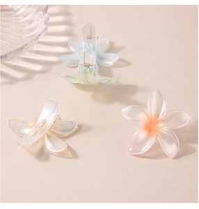 Detailed macro view of pearlescent flower hair clips with frosted gradient finish