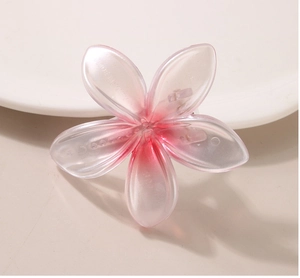 Close-up of pink pearlescent flower hair clip with gradient petals and resin texture