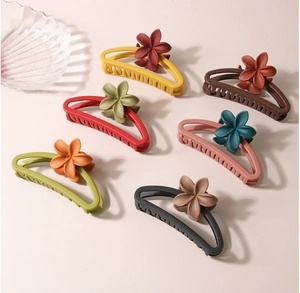 Macro detail of large matte flower hair claws in multiple colors with hollow design