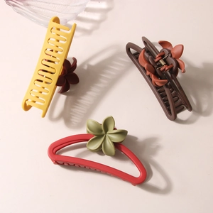 Three matte large hair claw clips featuring flower patterns in yellow, red and brown tones