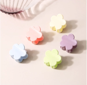 Macro shot of colorful pastel flower mini hair claws in pink, yellow, blue and purple