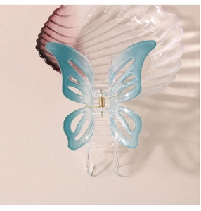 Vue détaillée d'une pince à cheveux papillon bleu dégradé avec ressort doré en métal