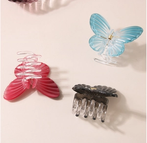 Detailed macro view of three colorful butterfly hair claws with gold springs and clear texture