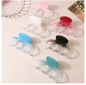 Detail view of large gradient octopus hair claws in pink, blue, and black colors