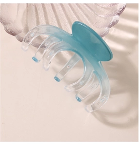 Detail of blue-green gradient large hair claw clip with smooth translucent resin texture
