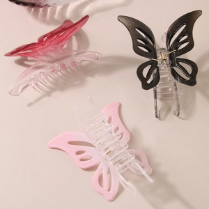 Trois pinces à cheveux papillon évidées en rose et noir sur un fond beige minimaliste