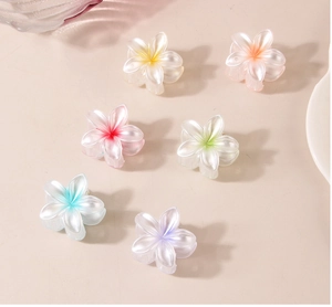 Détail de six petites pinces à cheveux fleur de frangipanier avec fini nacré brillant