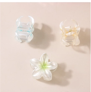 Vue détaillée de la pince à cheveux fleur nacrée et des pinces en résine avec ressorts dorés