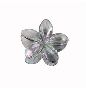 Détail macro de la pince à cheveux fleur de frangipanier avec finition laser irisée
