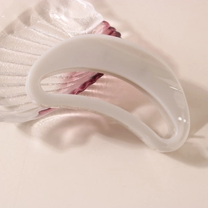 Pince à cheveux creuse blanche élégante et minimaliste pour cheveux épais sur plateau