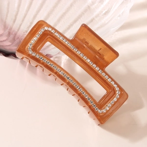 Elegante pinza per capelli rettangolare color ambra con strass su sfondo estetico curato