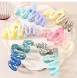 Macro detail of large wave hair claws with matte gradient colors and paint splatter effect