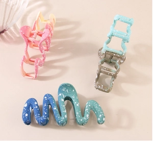 Detailed view of large wave hair claws with gradient colors and white speckled design
