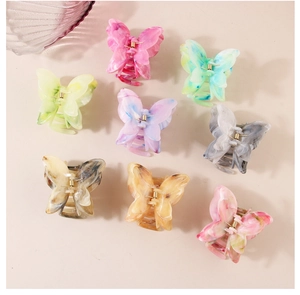 Close-up of butterfly hair claws featuring marble texture and sturdy metal springs