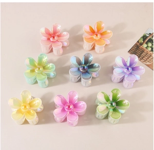 Vue à plat de huit pinces à cheveux fleurs colorées avec un fini nacré dégradé