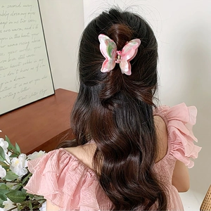 Detail of pink and green marble butterfly hair claw clip worn on a half-up hairstyle