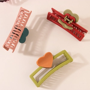 Three large matte heart hair claws in pink, red, and green for thick hair styling