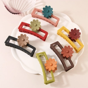 Detail showing seven matte rectangular hair claws with floral accents in various colors