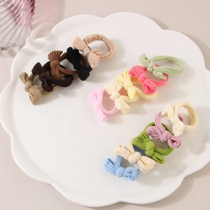 Ensemble de chouchous à nœuds élastiques aux tons pastels sur une assiette décorative