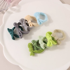 Lot de chouchous à nœuds en tissu couleurs Morandi sur plateau blanc pour femmes