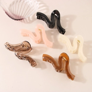 Detail showing five different colors of large wavy S-shaped hair claw clips for thick hair