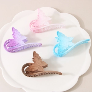 Detailed macro view of four butterfly hair claws in pink, purple, blue and brown colors