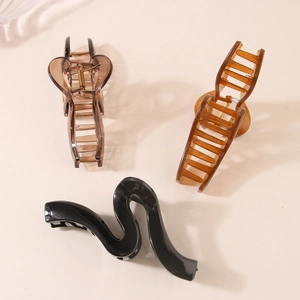 Three minimalist geometric wavy hair claw clips in brown, amber, and black resin finishes