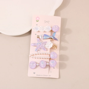 Detail of 5-piece sea star hair clip set featuring shells and pearls on a card