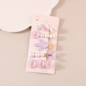 Detail showing a 5-piece set of ocean-themed hair clips with shells and pearls