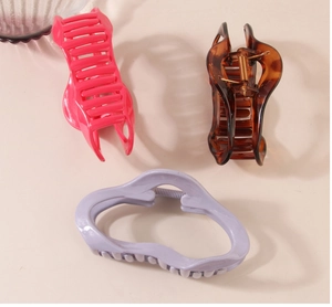 Three large hair claw clips in pink, tortoise pattern and lavender for thick hair